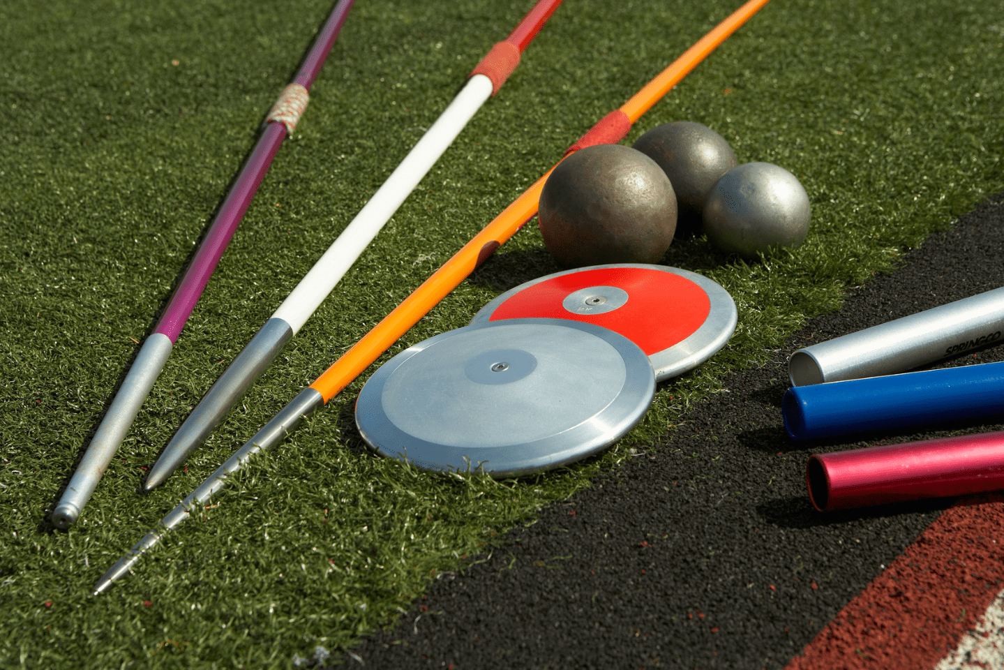 Track and field items on a grassy lawn. 