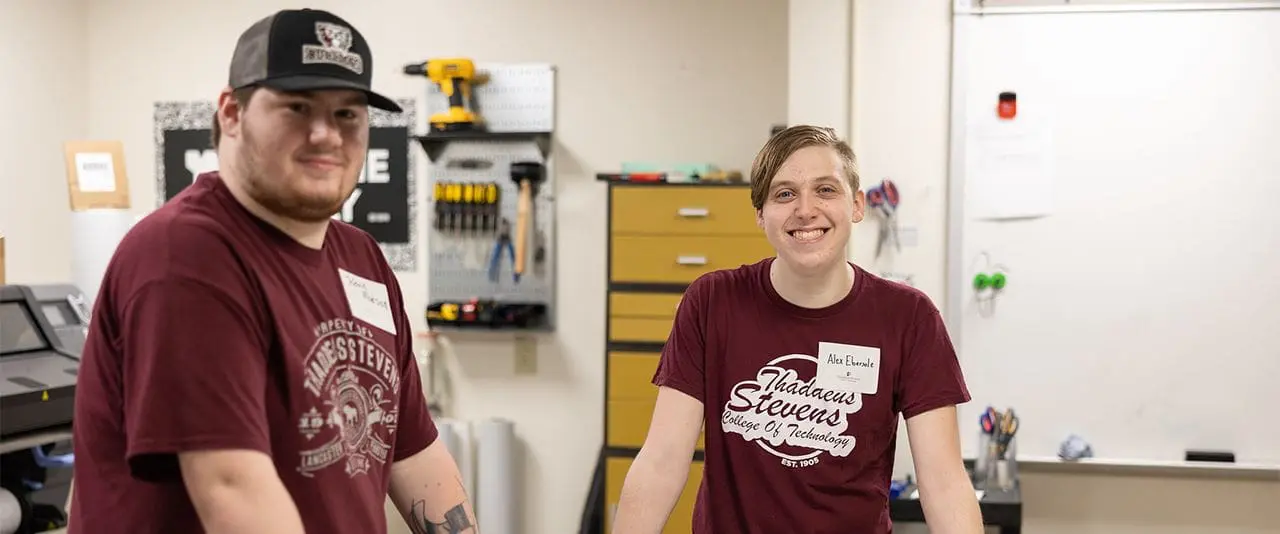 Two TSCT Student smiling and posing as they are sitting in a classroom