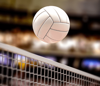 A volleyball flies over the net