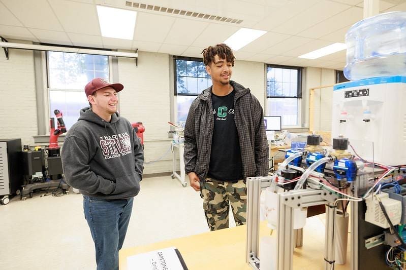 Thaddeus Stevens College Student talking and showing a prospective student a machine at open house