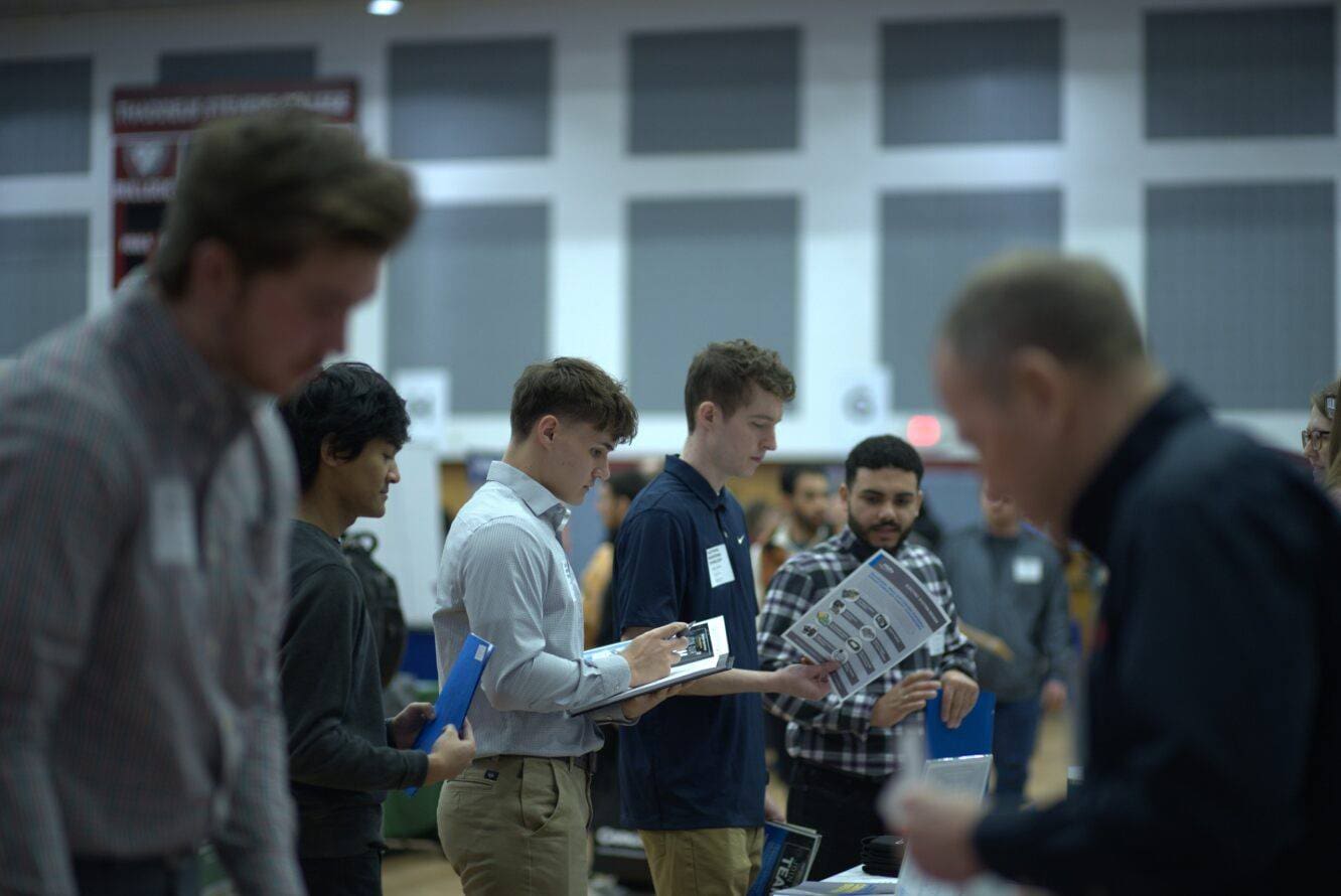 Students talk with recruiters at a job fair. 