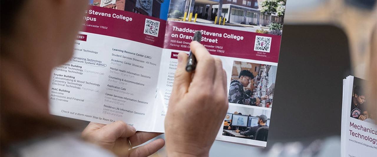 Thaddeus Stevens College student looking through Thaddeus Stevens informational