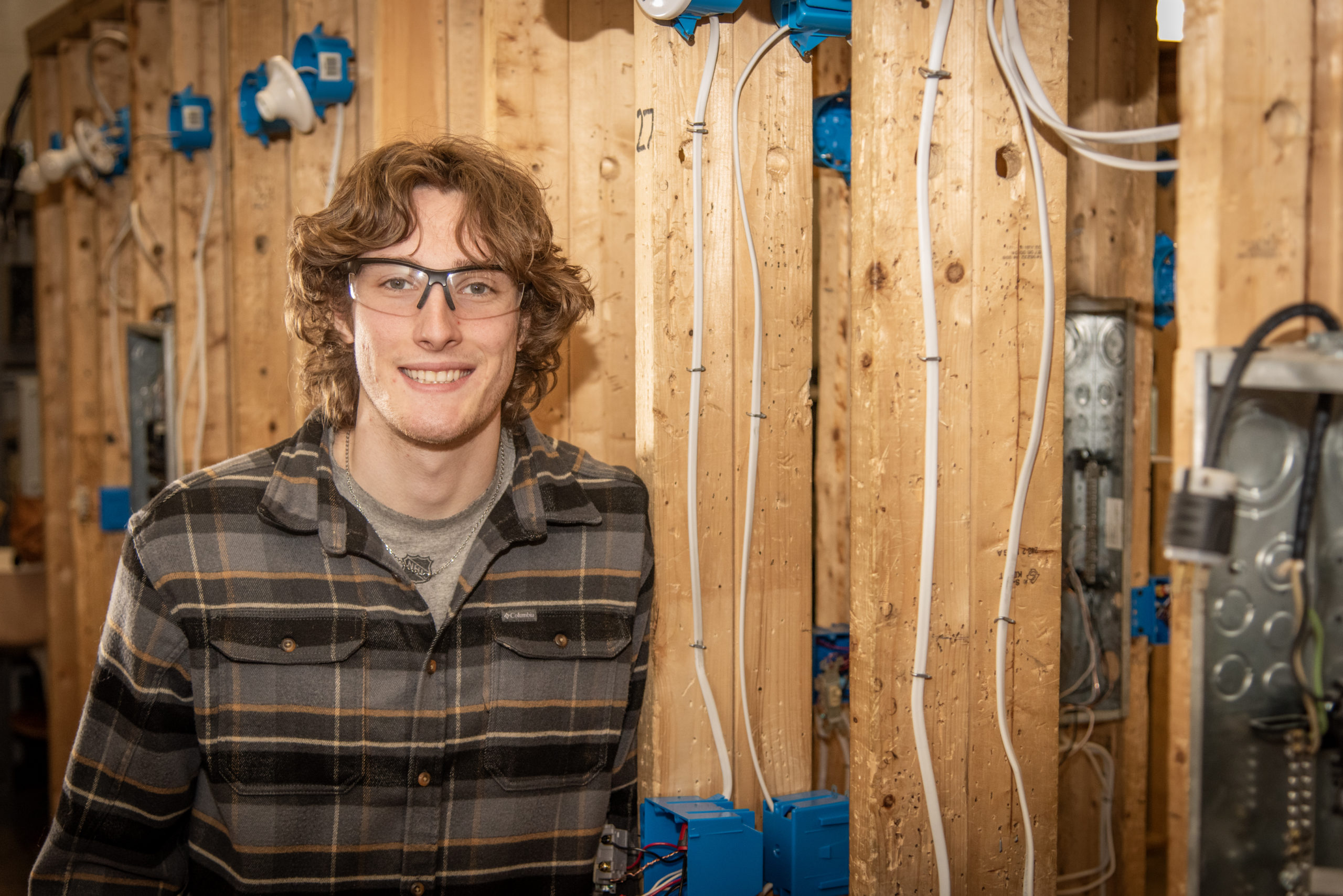 A student in the Electrical Technology program at Thaddeus Stevens College smiles at the camera while in the lab.